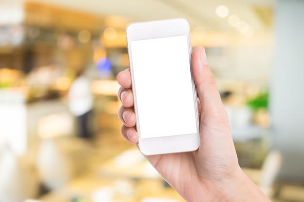 Woman hand holding white smartphone on blurred background