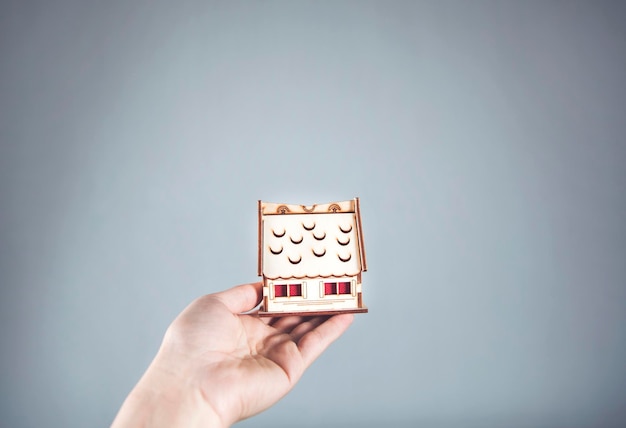 Woman hand holding wooden house model