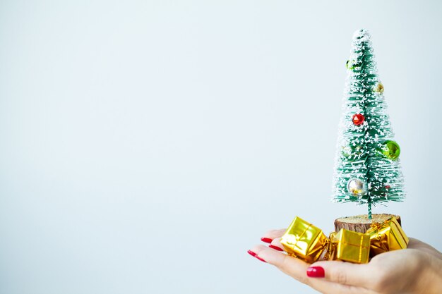 Woman in hand holds Christmas decorations on grey