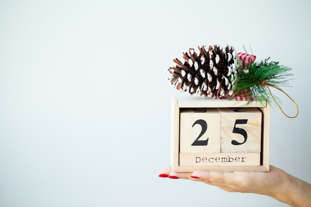 Woman in hand holds Christmas decorations on grey