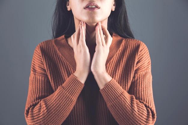 写真 喉の痛みで女性の手