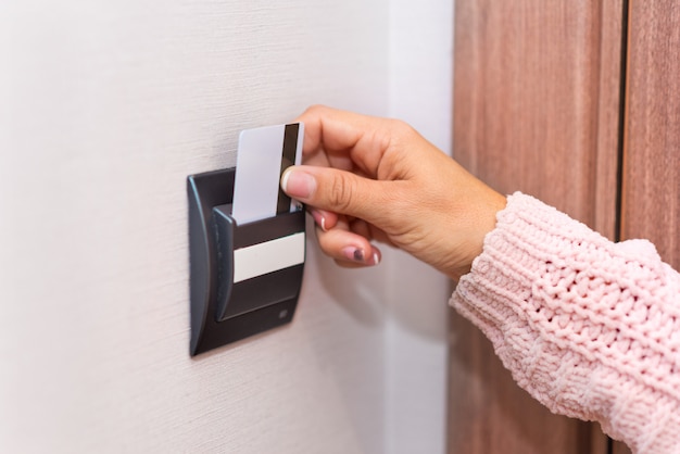 Woman hand inserting card in the hotel room