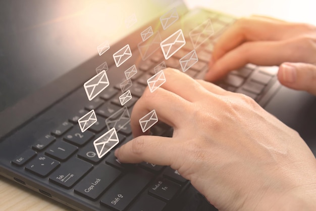 Woman hand is typing on keyboard of laptop to send email to customer to communicate promotion Market automation