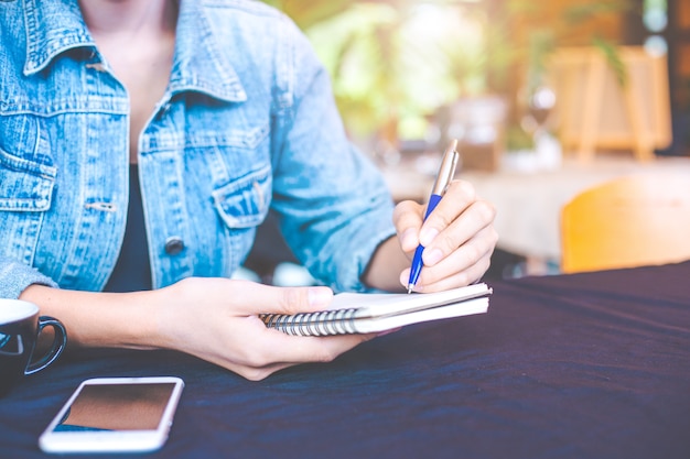 Woman hand is writing on a note pad 