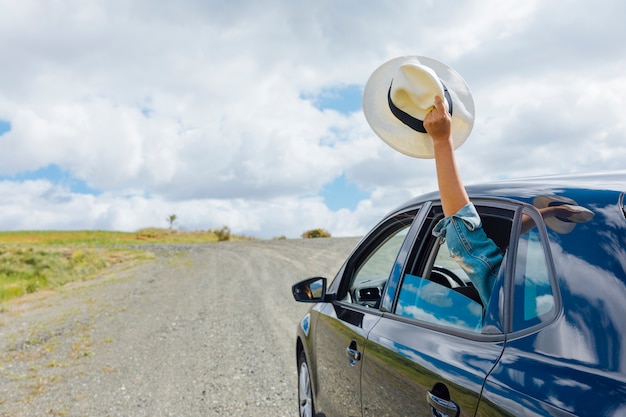 Foto mano della donna che tiene cappello nella finestra della macchina