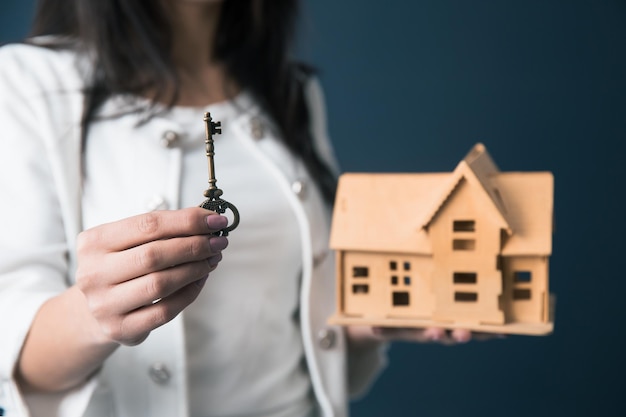 Woman hand key with house model