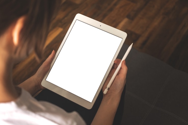 Woman hand on a mockup tablet with pencil, freelancer work job concept background photo