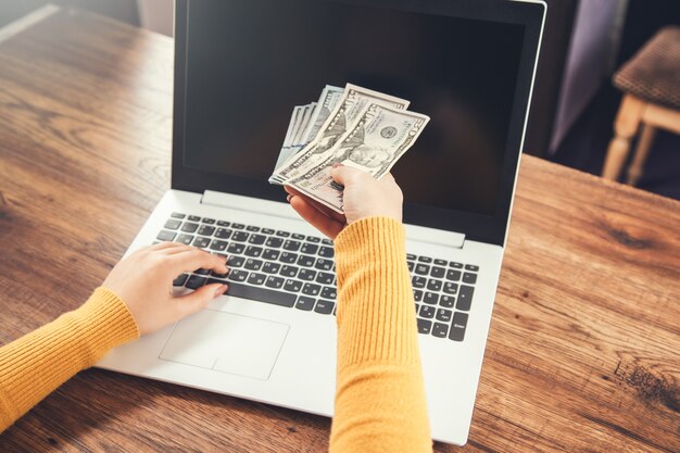 Photo woman hand money and computer on table