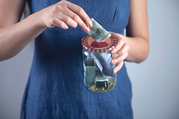 Woman hand money in jar