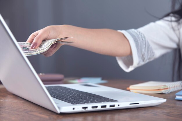 Woman hand money with computer