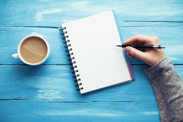 Woman hand notepad and coffee