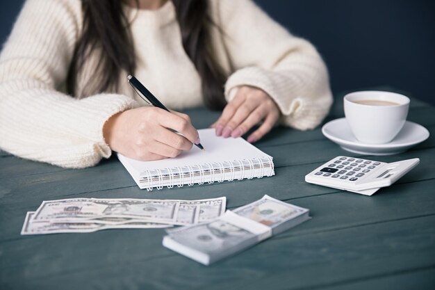 Woman hand notepad with money