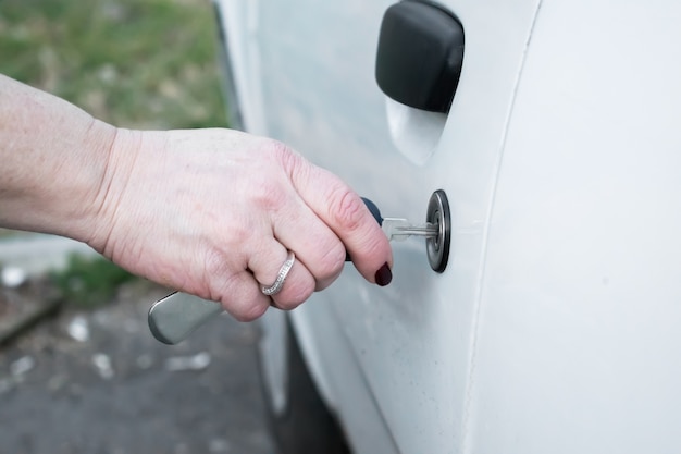 woman hand opening car door with key