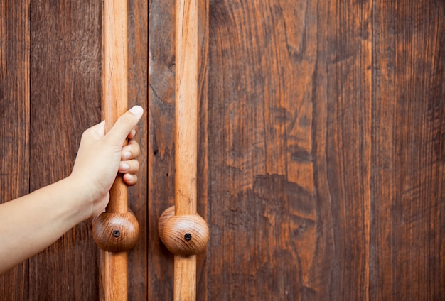 Woman hand opening/closing wooden door in vintage style