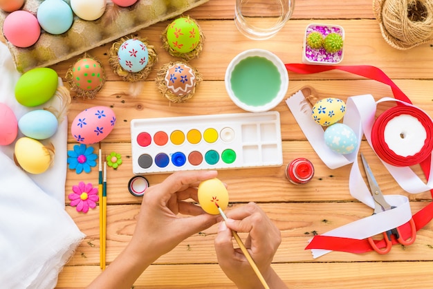 Woman hand painting Easter eggs. Happy family preparing for Easter.