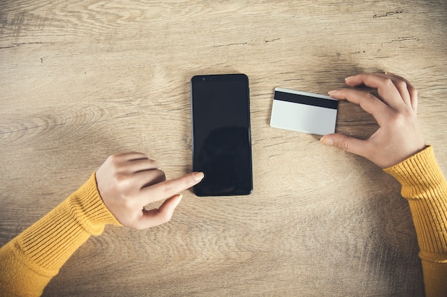 Woman hand phone and credit card on the table