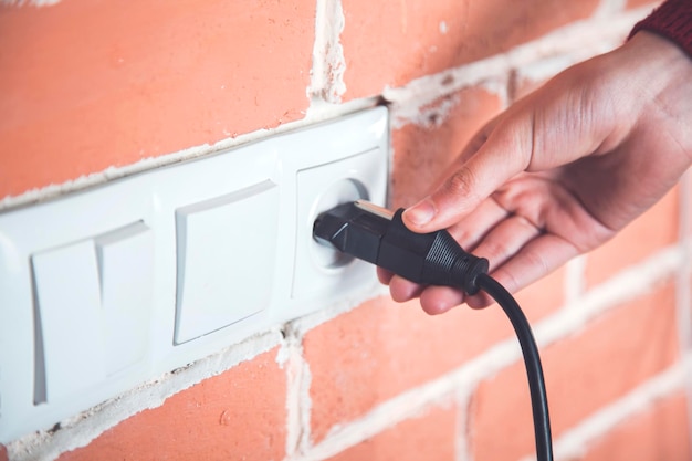 A woman hand pulls a black cord