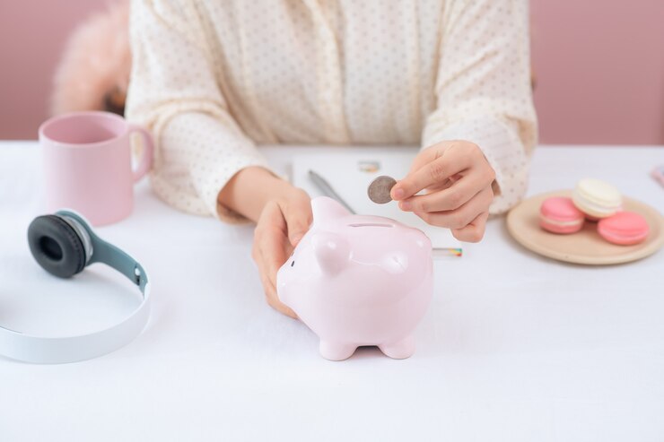 Photo 貯金箱、屋内にコインを置く女性の手