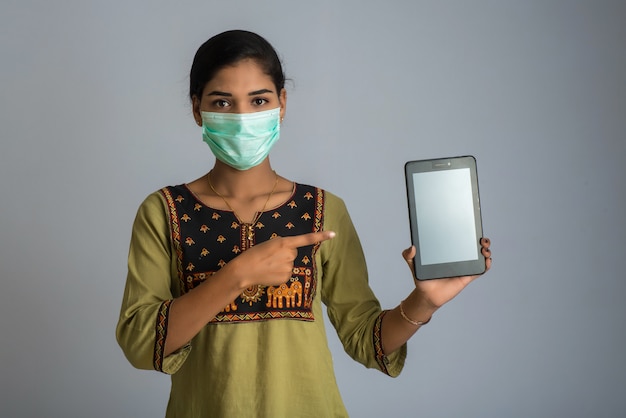 Woman hand showing smart mobile phone with safety medical face mask, Health care and infection concept