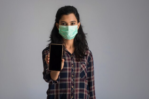 Woman hand showing smart mobile phone with safety medical face mask for prevent Coronavirus or Covid19, Health care and infection concept