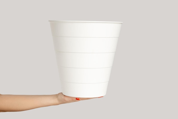 Woman hand showing white plastic waste bin