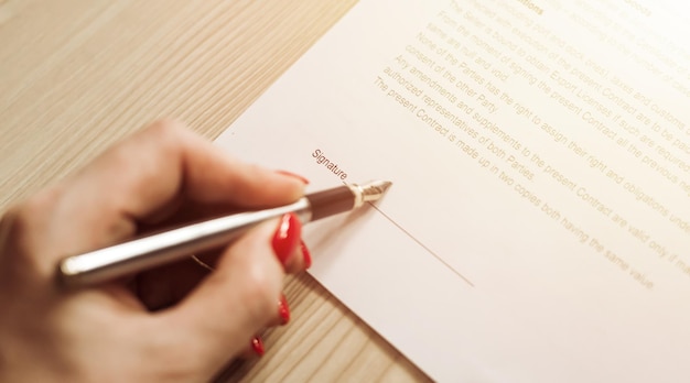 Woman hand signing a contract