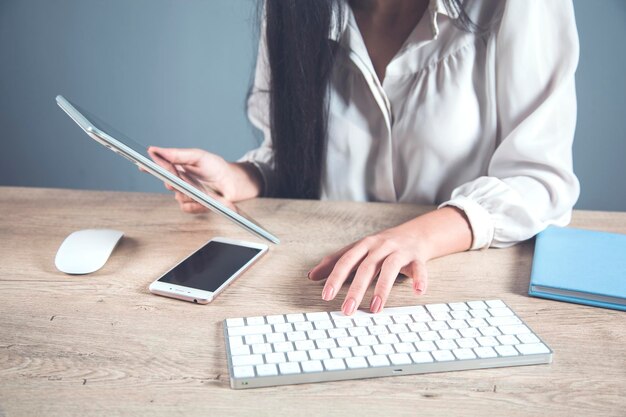 電話とコンピューターを備えた女性の手のタブレット