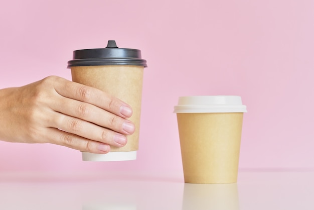 Woman hand take on of two coffee paper cup