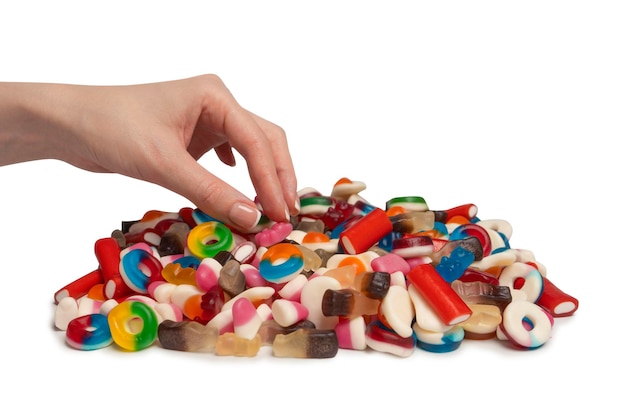 Woman hand takes a jelly candy on white background