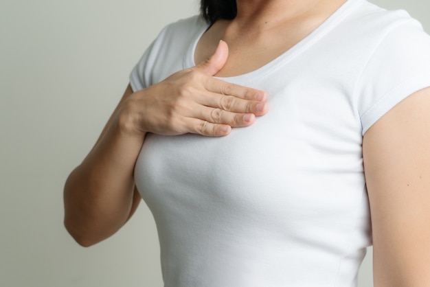 Woman hand touching chest to support breast cancer cause. breast cancer awareness concept