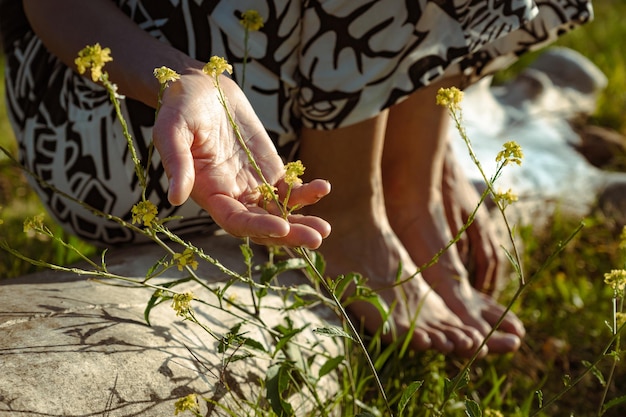 Foto fiori commoventi della mano della donna in prato