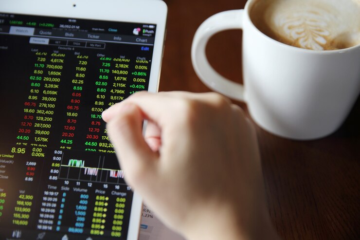 Photo 女性の手のビジネス紙とコーヒーとタブレットでオンライン取引