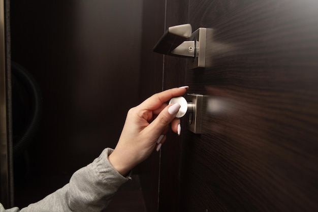 Woman hand unlocking door with key