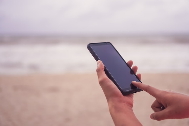 Woman hand use smartphone to do work business, social network, communication in public.