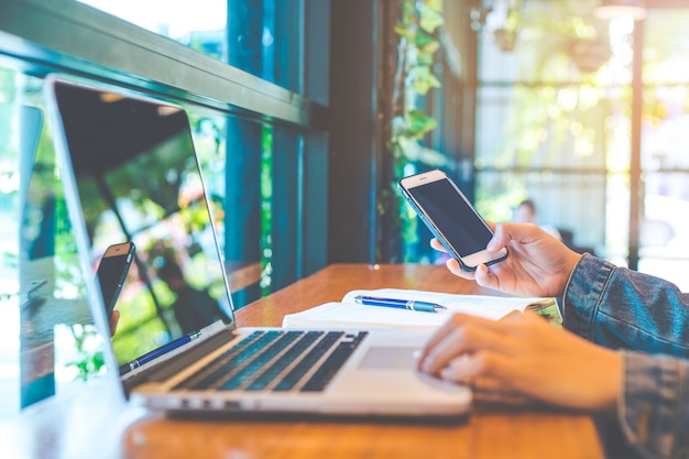 Foto la mano della donna utilizza un telefono cellulare e funziona