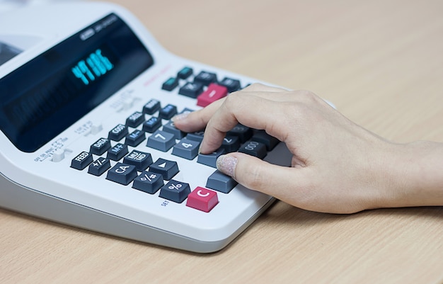 Woman hand using calculator