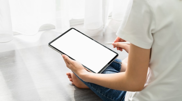 デジタルタブレットを使用している女性の手と画面が空白です。