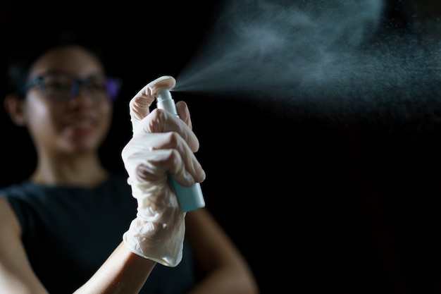 Woman Hand using sanitizer spray, alcohol spraying disinfectant to stop spreading  coronavirus or COVID-19.