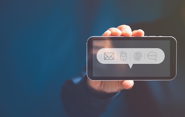 スマートフォンを使用する女性の手私たちに連絡してください接続コンセプト私たちに接続してくださいまたは顧客サポートホットライン人々仮想画面コンタクトアイコンメールアドレスライブチャットインターネットWi-Fi