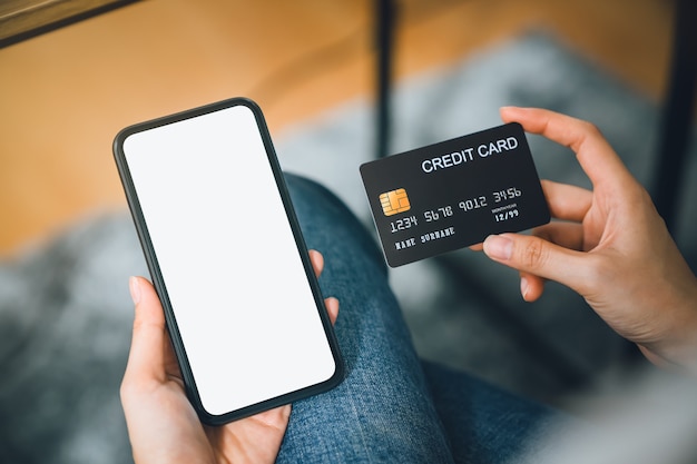 Photo woman hand using smartphone and holding credit card with payment online on mobile.