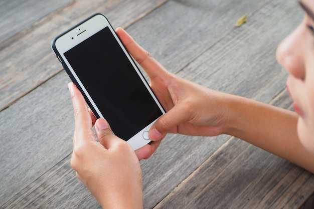 Woman hand using smartphone with blank display.