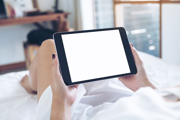 Woman hand using tablet pc on the bed