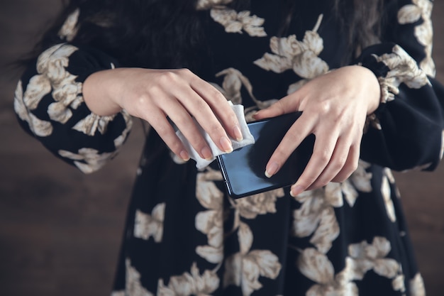 Женская рука мокрая салфетка и телефон