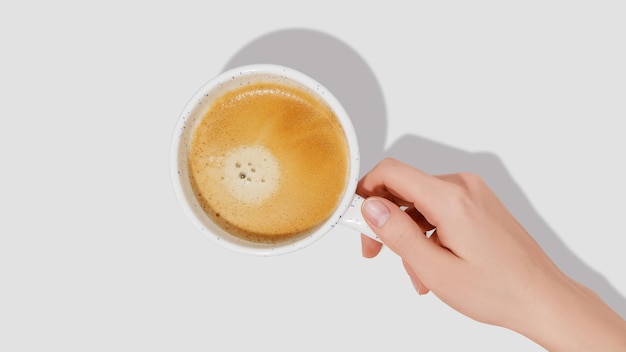 Woman hand and white coffee cup on white background