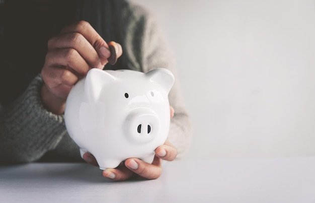 Woman hand and white piggy bank to saving money concept budget financial