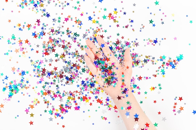 Woman hand with festive color star confetti