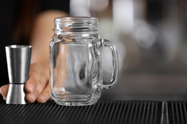 Photo woman hand with glass jar on bar counter