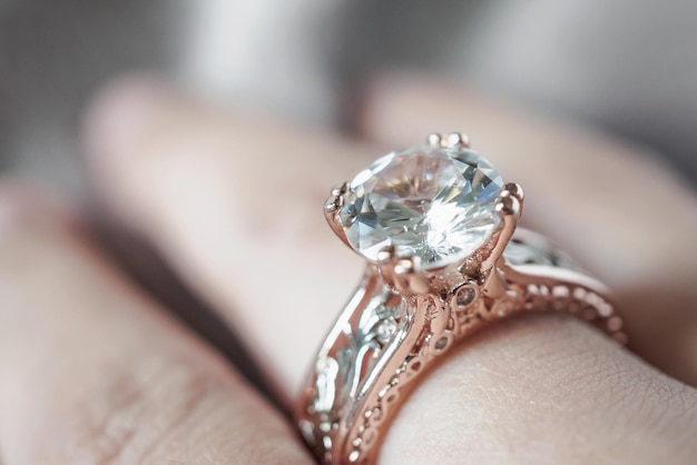 指に宝石のダイヤモンドの指輪を持つ女性の手
