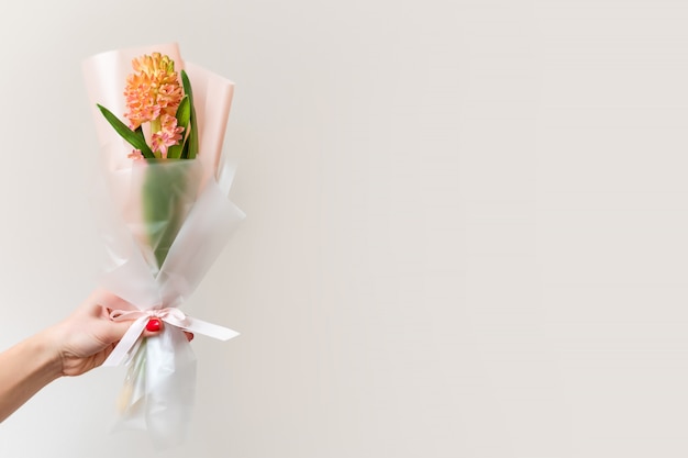 Woman hand with manicure holding spring flowers.