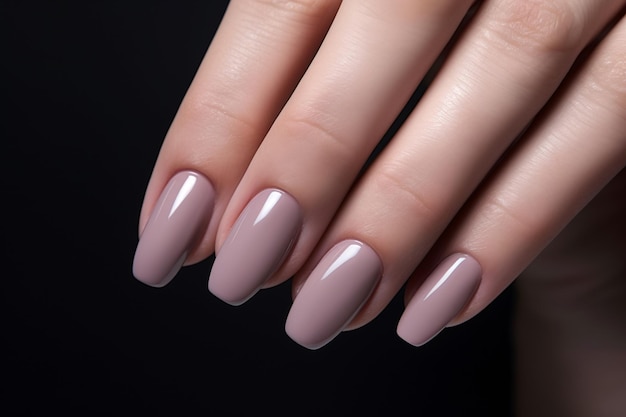 Woman hand with nude shades nail polish on her fingernails Nude color nail manicure with gel polish